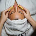 Relaxing spa treatment with facial and sponge massage in a serene environment.